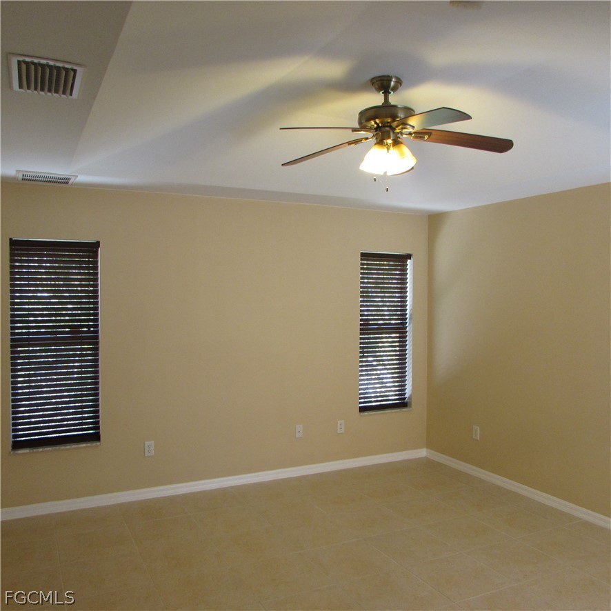 5773 Marina Road Bokeelia, FL 33922 - Photo 18 of 27 an empty room with windows and chandelier fan
