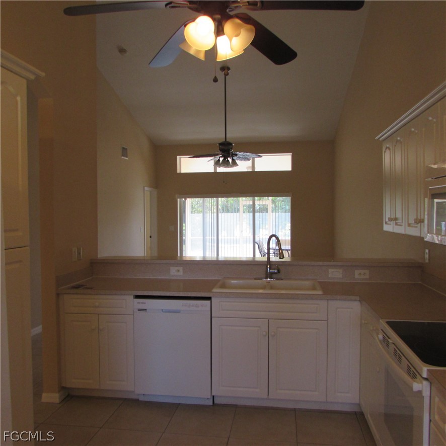5773 Marina Road Bokeelia, FL 33922 - Photo 8 of 27 a kitchen with granite countertop a sink and white cabinets