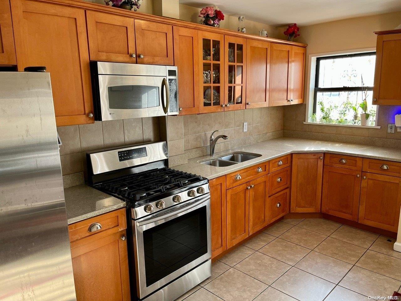 a kitchen with stainless steel appliances granite countertop a stove a sink and a microwave