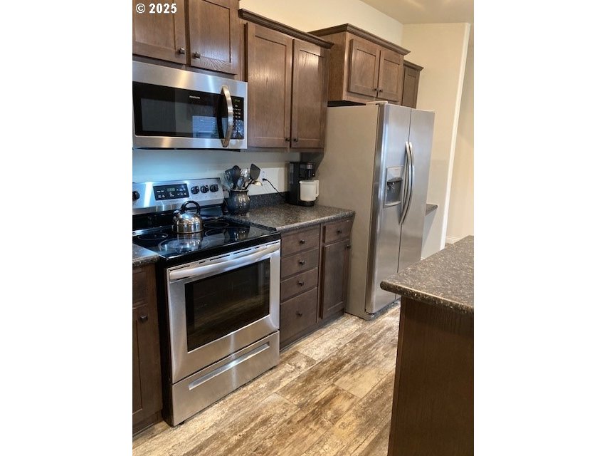 3075 Southwest River View Drive Pendleton, OR 97801 - Photo 10 of 34 a kitchen with stainless steel appliances a stove a microwave and refrigerator