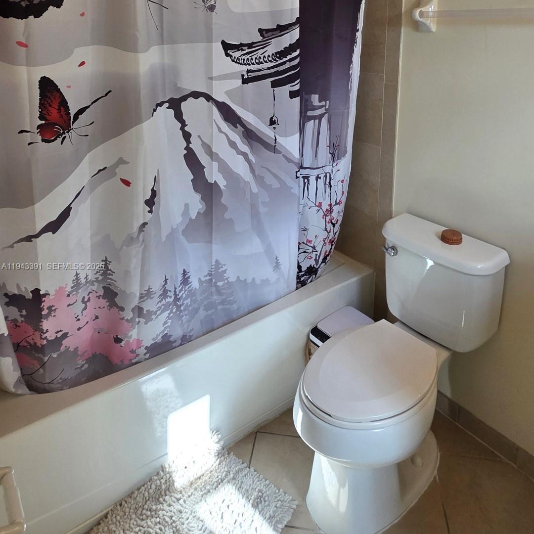 3203 Southeast 7th Street Homestead, FL 33033 - Photo 35 of 44 a bathroom with a toilet and a shower curtain