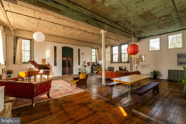 a living room with furniture a flat screen tv and a window