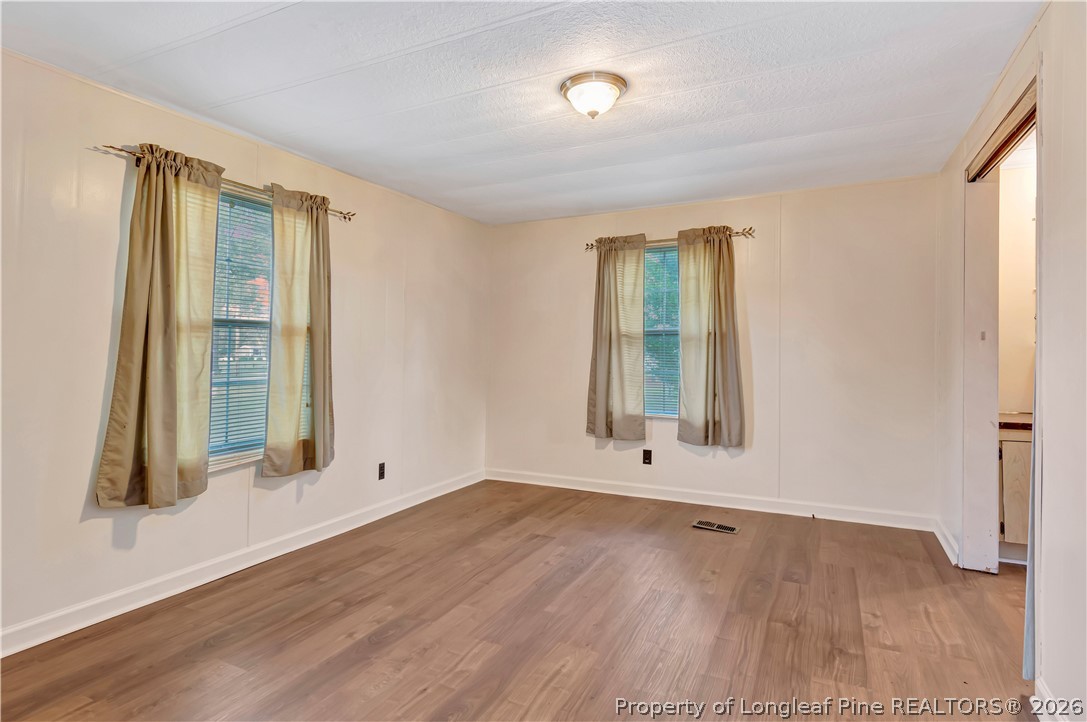 727 Rice Road Lumberton, NC 28358 - Photo 13 of 30 an empty room with wooden floor and windows
