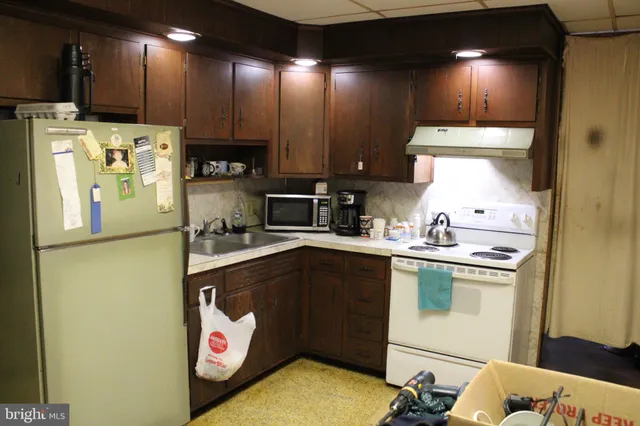 a kitchen with a sink a refrigerator and cabinets