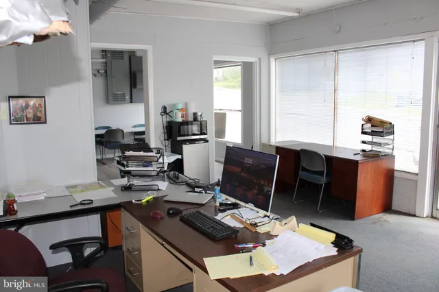 a view of a workspace with furniture and a window