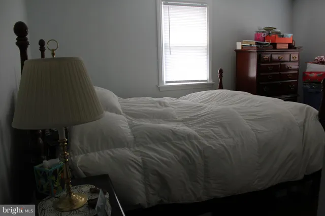 a bed sitting in a bedroom next to a window