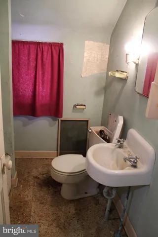 a bathroom with a toilet a sink and mirror