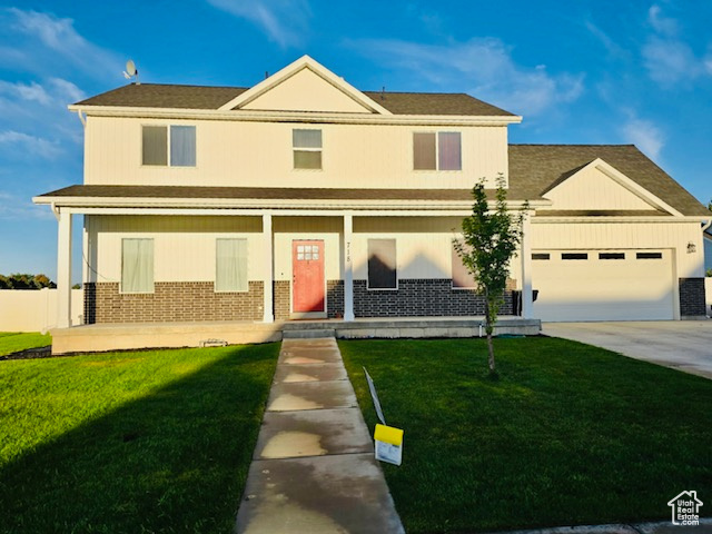 718 700 East Preston, ID 83263 - Photo 3 of 45 View of front of property featuring covered porch, brick siding, driveway, and a garage