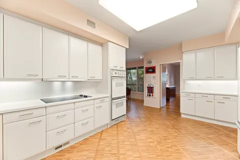 a kitchen with white cabinets and white appliances