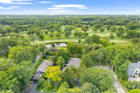 an aerial view of residential houses with outdoor space and trees