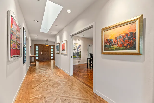 a view of a hallway with wooden floor and furniture