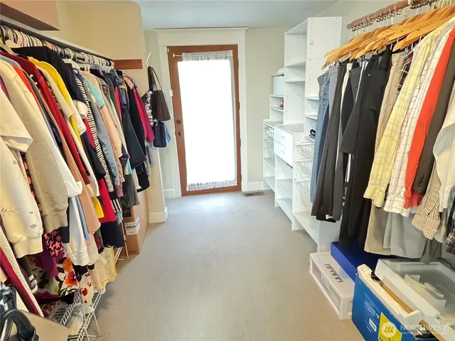 a view of walk in closet with clothes and shoes