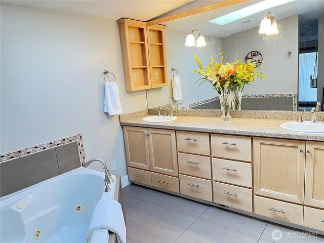 a bathroom with a sink mirror and a bathtub