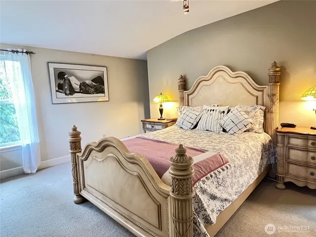 a bedroom with a bed and a painting on the wall