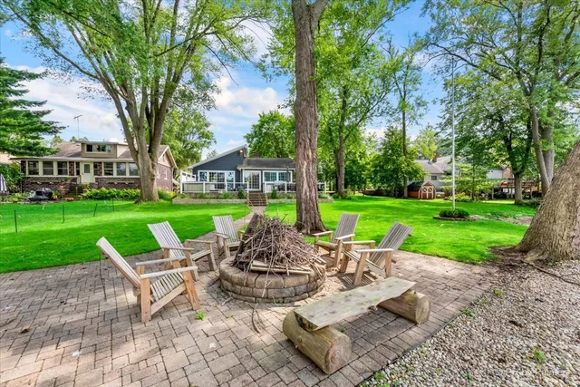a view of a chair and table in backyard of the house