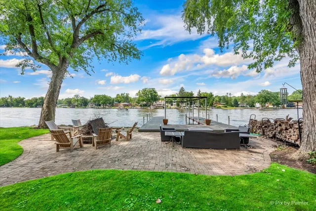 a view of a lake with couches and wooden fence