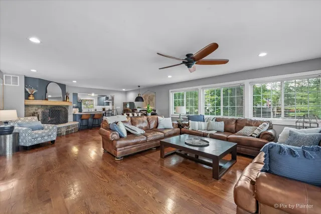 a living room with furniture a fireplace and a large window