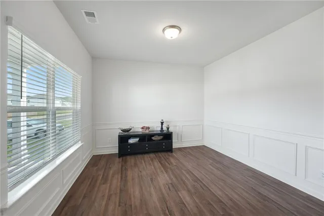 a living room with furniture a flat screen tv and a window