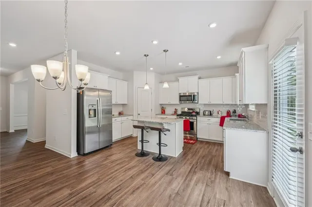 a spacious bedroom with a bed and a chandelier