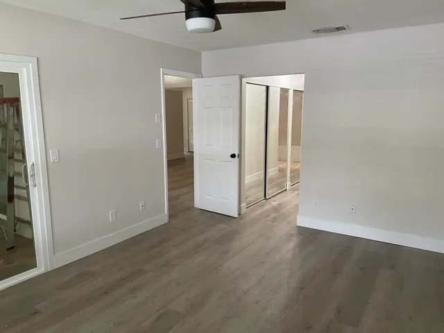 an empty room with wooden floor and closet area