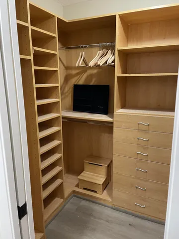 a view of walk in closet with empty racks