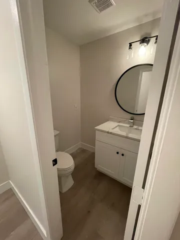 a bathroom with a granite countertop sink toilet and a mirror