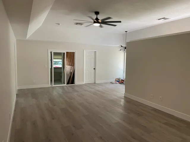 a view of a livingroom with a ceiling fan a ceiling fan and hardwood floor
