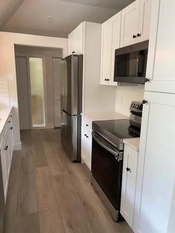 a kitchen with stainless steel appliances a refrigerator a stove top oven a sink and cabinets