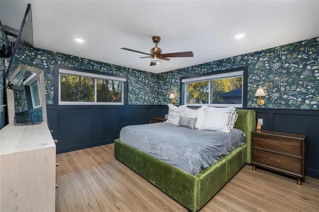 a bedroom with a bed and a dresser with wooden floor