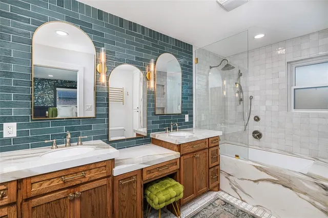 a spacious bathroom with a double vanity sink mirror and a bath tub