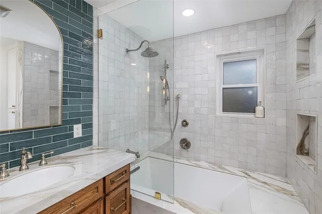 a bathroom with a granite countertop sink a toilet and shower
