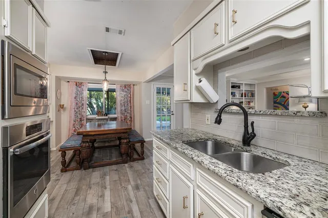 a kitchen with stainless steel appliances granite countertop a sink and a refrigerator