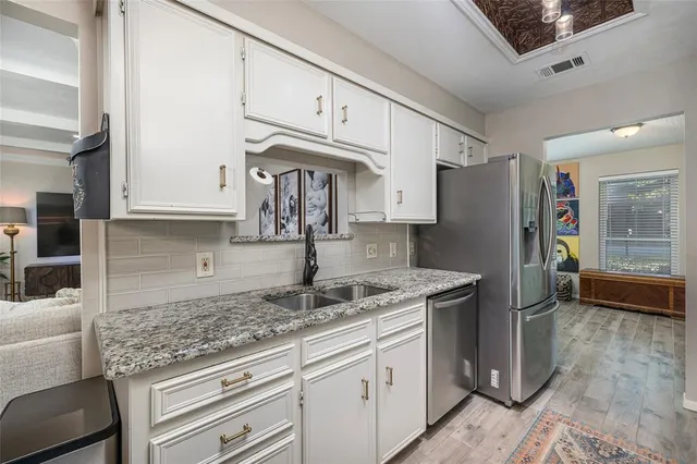 a kitchen with stainless steel appliances granite countertop a refrigerator sink and cabinets