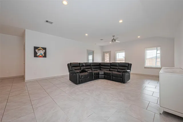 a kitchen with stainless steel appliances a stove a sink a refrigerator and white cabinets with wooden floor