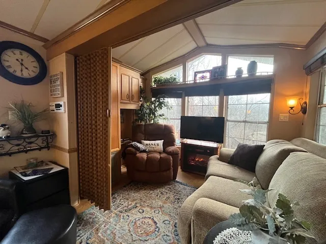 a living room with furniture a fireplace and large windows