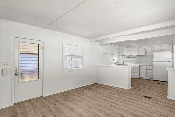 a view of a kitchen with wooden floor and windows