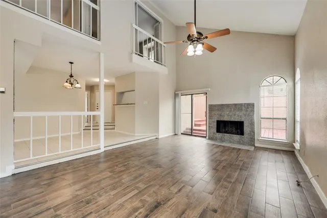 wooden floor fireplace and windows in an empty room