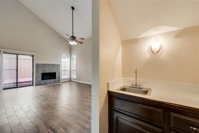 a view of a livingroom with a fireplace and a chandelier fan