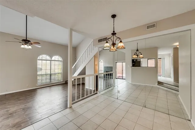 a view of a livingroom with a chandelier wooden floor and chandelier