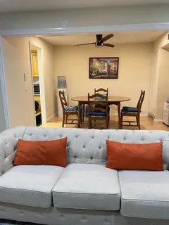 a living room with furniture and wall paintings