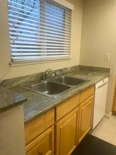 a kitchen with granite countertop sink and cabinets