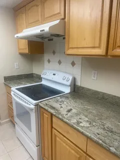 a utility room with granite countertop cabinets washer and dryer
