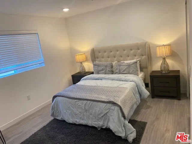 a bedroom with a bed and a night stand