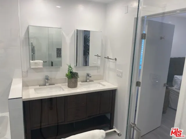 a bathroom with double sink and two mirror