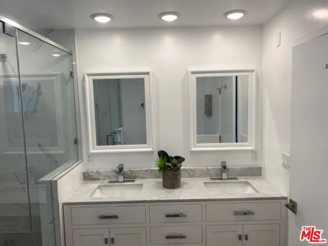 a bathroom with double sink and a mirror