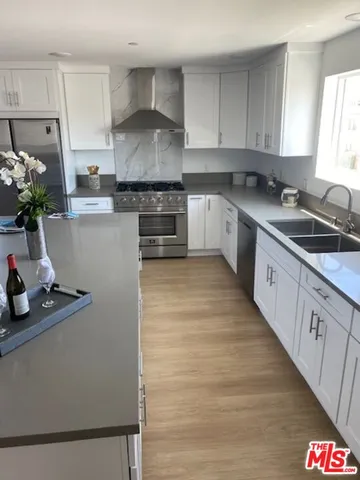 a kitchen with granite countertop a sink stove and cabinets