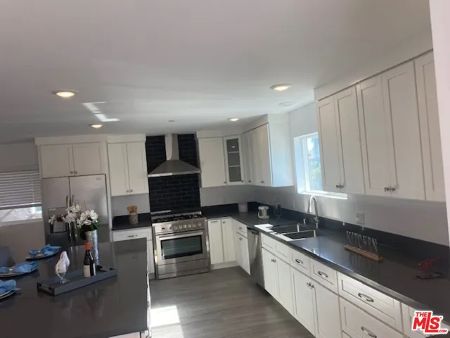 a kitchen with granite countertop a sink stainless steel appliances and cabinets