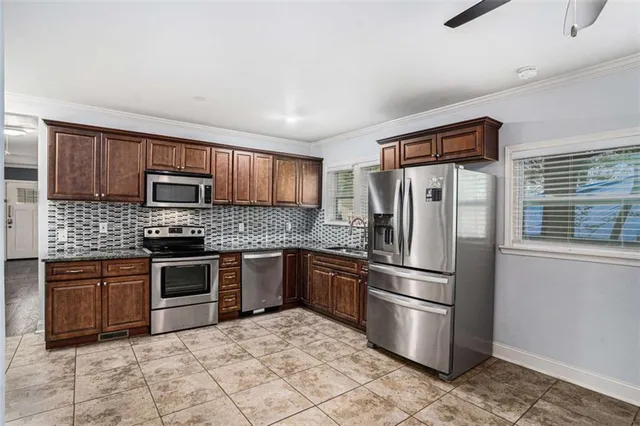 a kitchen with stainless steel appliances granite countertop a refrigerator and a stove top oven