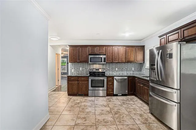 a kitchen with stainless steel appliances granite countertop a refrigerator and a stove top oven