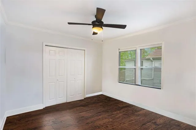 a view of empty room with wooden floor and window